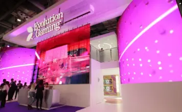 Evolution Gaming-monter med futuristisk design och rosa LED-skärmar på ICE-spelmässa.