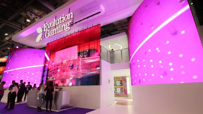 evolution-intakter-2025 Evolution Gaming-monter med futuristisk design och rosa LED-skärmar på ICE-spelmässa.