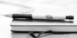 Spelinspektionen inför nya tillsynsavgifter från mars 2026 Kulspetspenna med Spelinspektionens logotyp liggande på en stängd anteckningsbok