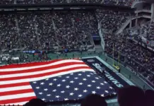 Amerikansk flagga täcker planen inför Super Bowl i fullsatt NFL-arena med publik på läktarna.
