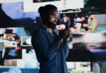 Studie visar starkast reklampåverkan hos problemspelare Man använder mobil framför flera skärmar med reklam och bilder som symboliserar exponering för spelreklam