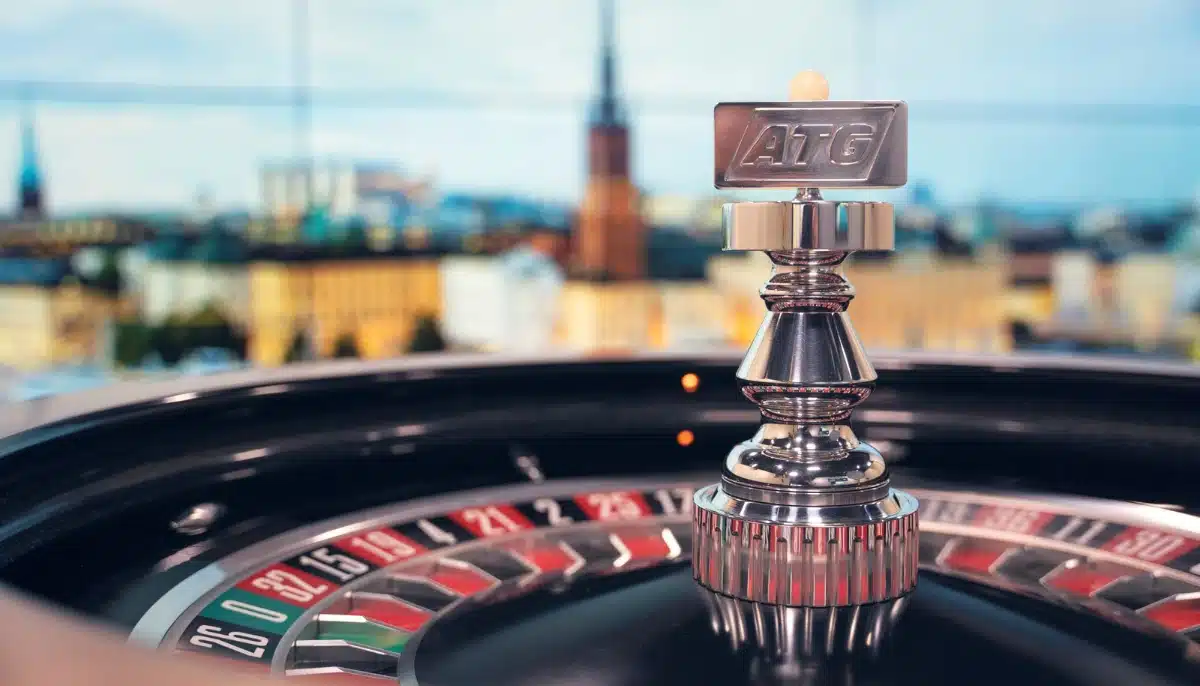 ATG logotyp på roulettehjul i förgrunden med stadsmiljö i bakgrunden