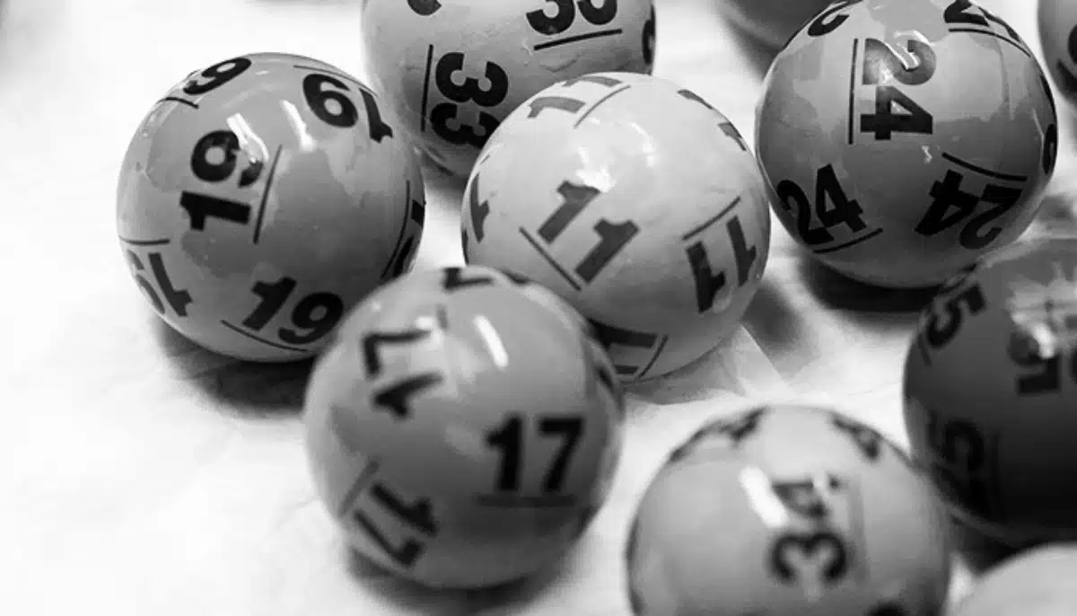 Närbild på bingobollar med siffror spridda på ett bord i en bingohall