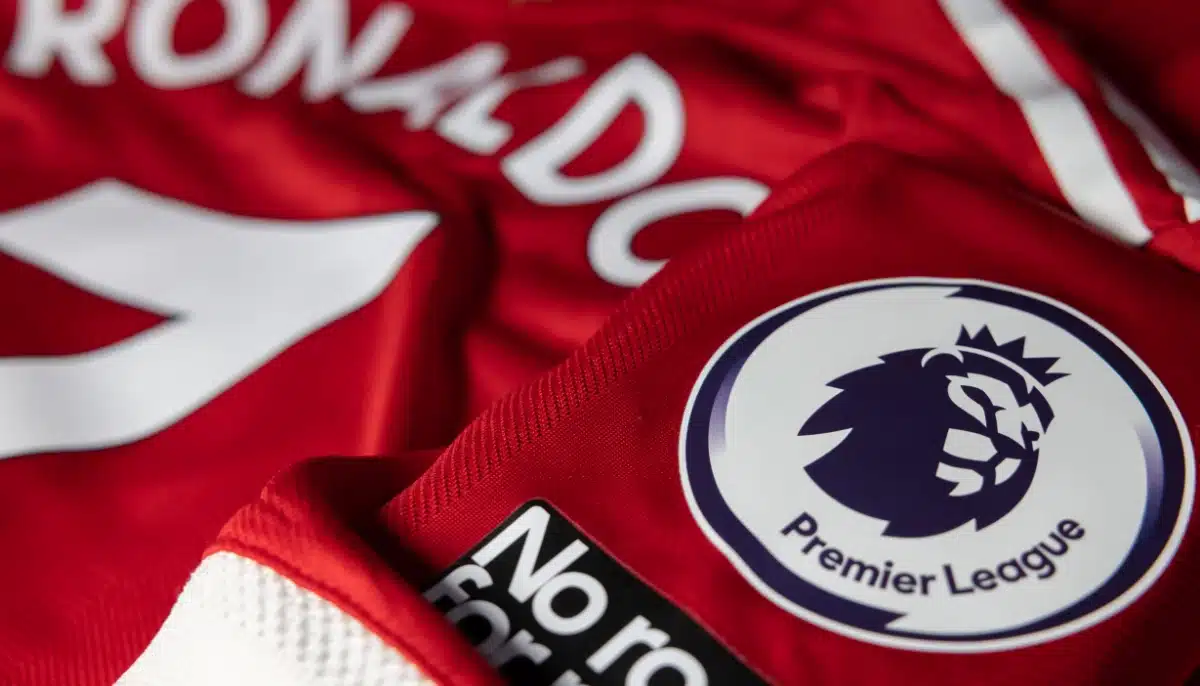 Premier League logotyp på röd fotbollströja med sponsortryck i närbild