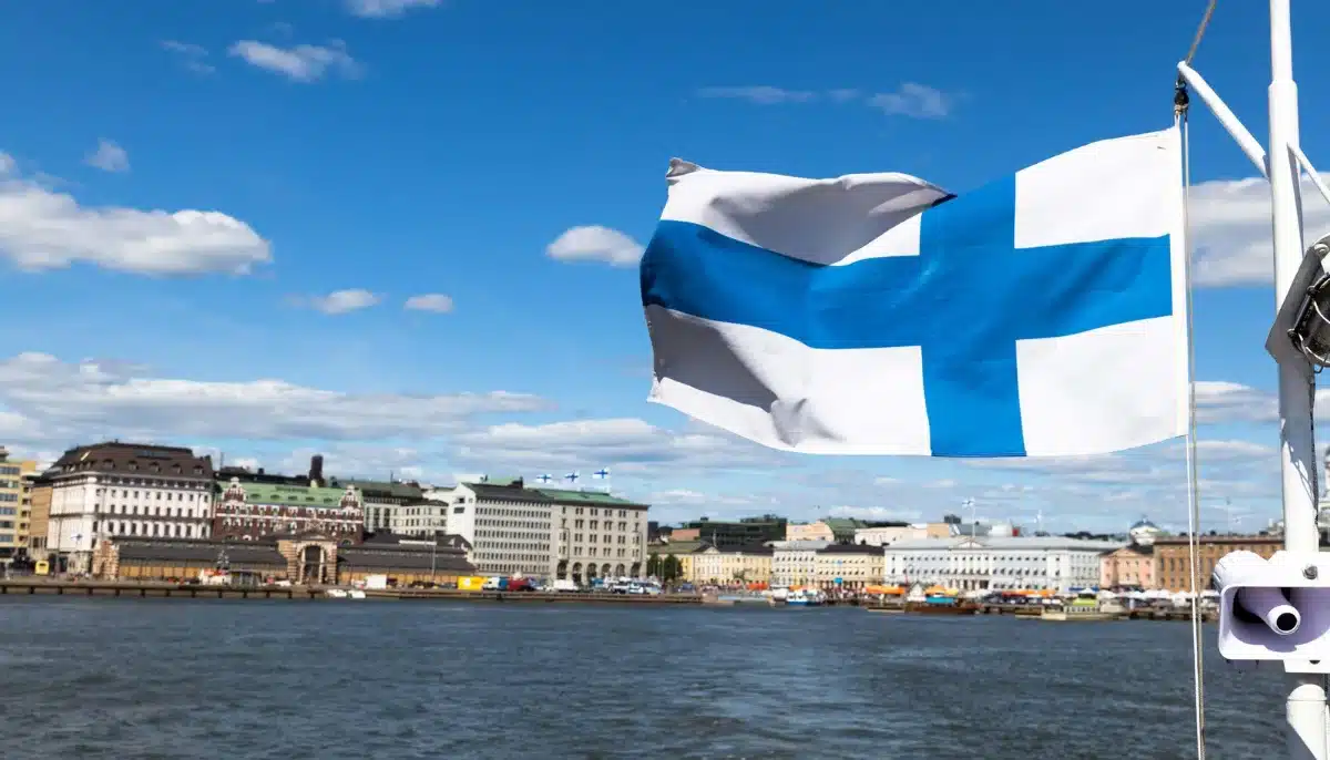 Finlands flagga vajar framför Helsingfors hamn och stadssiluett