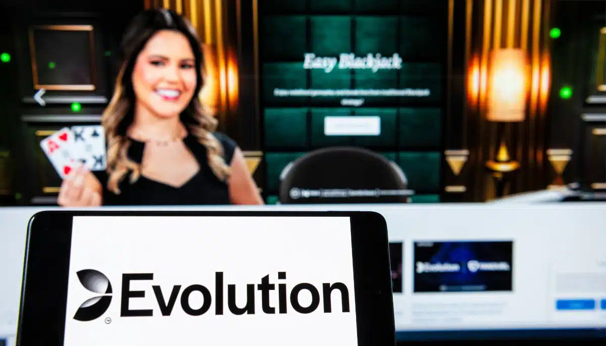Evolutions logotyp framför en skärm med en dealer i live casino