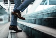 Motivation and challenging Concept. Steps Forward into a Success. Low Section of Businessman Walking Up on Staircase.