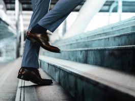 Motivation and challenging Concept. Steps Forward into a Success. Low Section of Businessman Walking Up on Staircase.