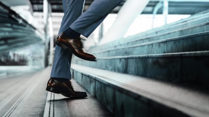 Motivation and challenging Concept. Steps Forward into a Success. Low Section of Businessman Walking Up on Staircase.