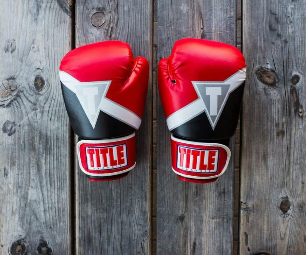 Two UFC gloves on a wooden canvas.