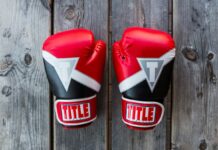 Two UFC gloves on a wooden canvas.