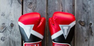 Two UFC gloves on a wooden canvas.