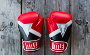 Two UFC gloves on a wooden canvas.