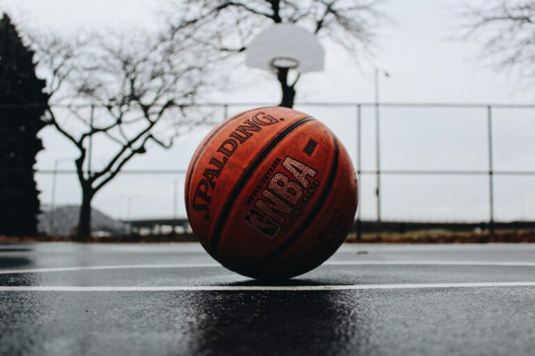 an nba basketball laying on a blacktop surface
