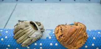 Japanese Baseball Players Escape Indictment Over Online Casino Gambling A pair of baseball gloves resting on a blue and white rail