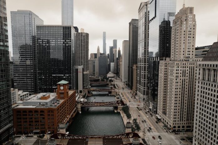 Aerial view of downtown Chicago with skyscrapers and river bridges on a cloudy day.