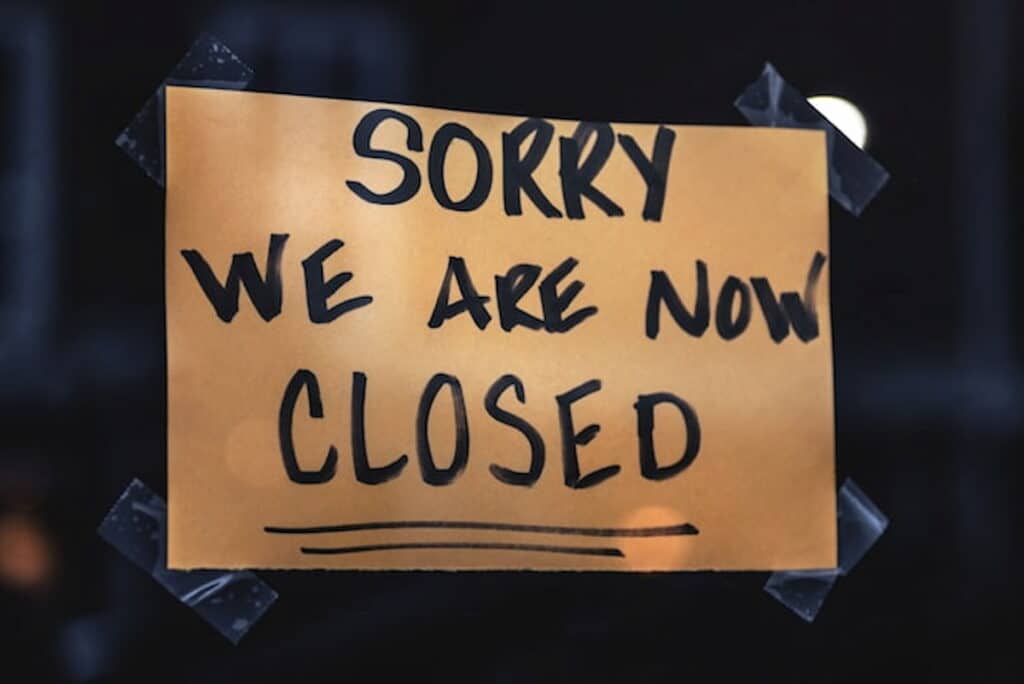 Handwritten "Sorry We Are Now Closed" sign taped to a window.