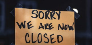 Handwritten "Sorry We Are Now Closed" sign taped to a window.