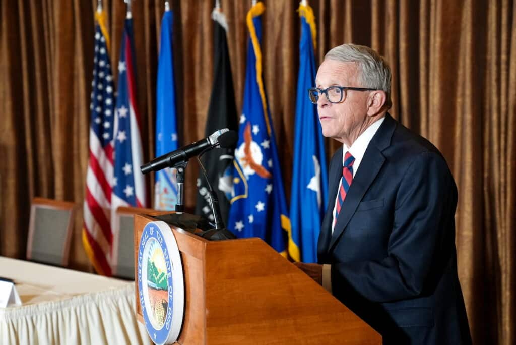 Ohio Governor Mike DeWine speaks at a podium during a Memorandum of Understanding signing between the Air Force Research Laboratory and the State of Ohio.