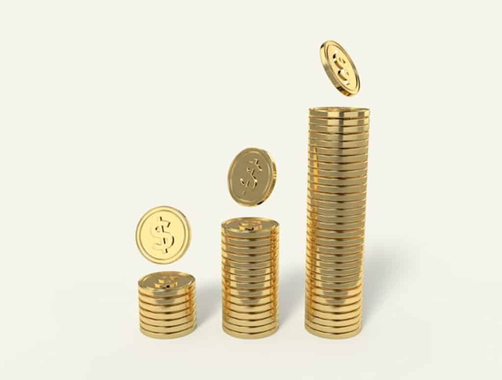 Stacks of gold coins increasing in height, with individual coins floating above each stack on a light background.