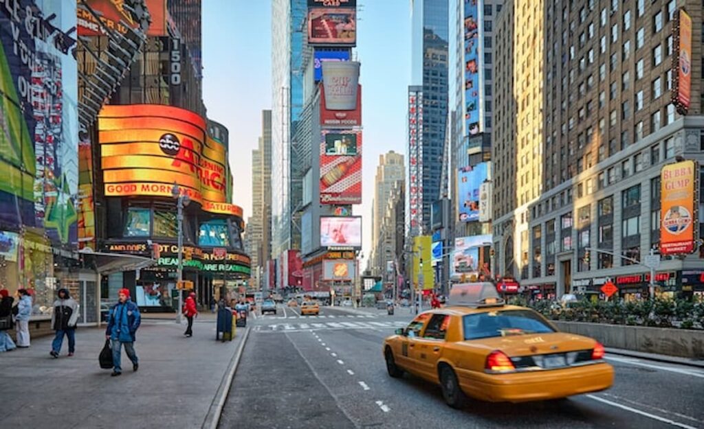 Times Square streetscape with yellow taxi and digital billboards near 1515 Broadway.