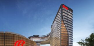 Rendering of Bally’s proposed Bronx casino resort exterior with glass tower and illuminated entrance canopy.