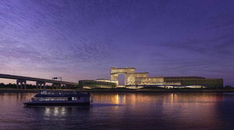 Nighttime rendering of Bally’s proposed Bronx casino resort viewed from the East River with ferry in foreground.