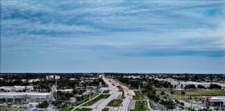 Florida Authorities Seize 428 Gambling Machines, $540K in Cash During Major Raid Aerial view of a Cape Coral highway surrounded by businesses and neighborhoods in Florida.