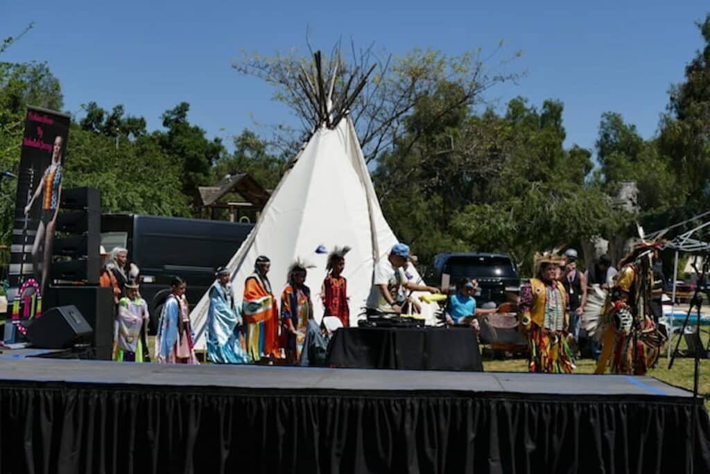 Native American tribal members in traditional regalia at a cultural event.