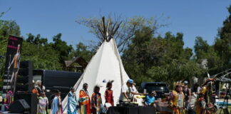 Native American tribal members in traditional regalia at a cultural event.