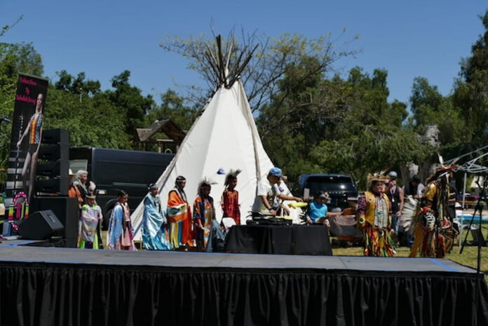 Native American tribal members in traditional regalia at a cultural event.