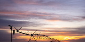 Agricultural irrigation equipment silhouetted against a Nebraska sunset.