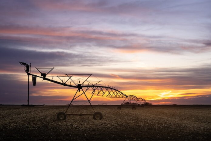 Agricultural irrigation equipment silhouetted against a Nebraska sunset.