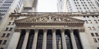 Facade of the New York Stock Exchange with flags and columns.