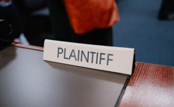 Courtroom sign reading “Plaintiff” on a desk