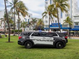 Florida Seizes Over $350K, 623 Slot Machines Amid Lawmakers’ Push for Anti-Gambling Bill Police SUVs parked on grass in front of palm trees and art deco buildings