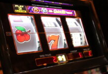 BetMGM Faces Lawsuit Over Alleged Rule Change in $500K Online Casino Promotion Close-up of a traditional slot machine showing spinning reels with symbols.
