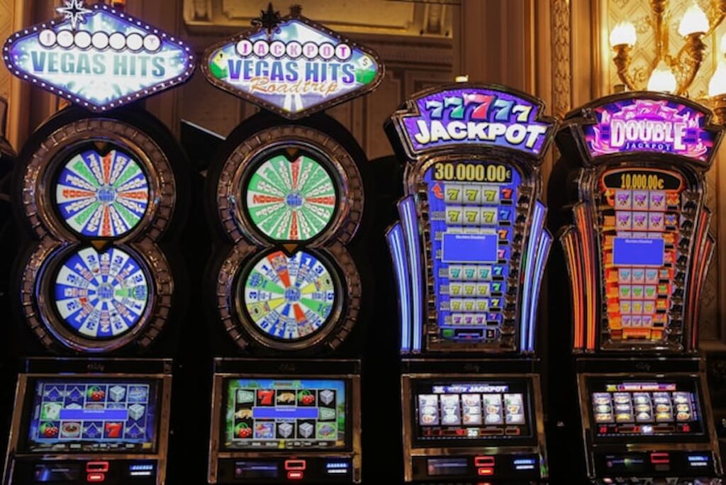 Slot machines with jackpot signage and flashing lights inside a casino