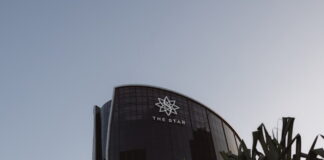 The Star Entertainment building in Australia, with logo visible on curved glass facade under a clear sky.