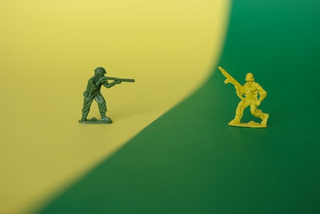 Toy soldiers facing each other on a split green and yellow background.
