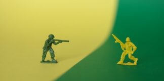 Toy soldiers facing each other on a split green and yellow background.