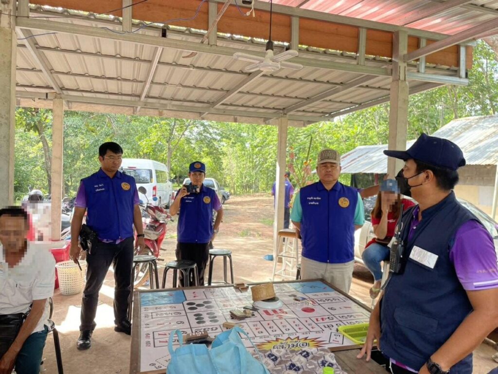 Thai police officers seize a HiLo table during their raid on a suspected gambling den.