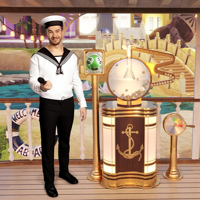Man in sailor uniform standing by lottery machine with microphone