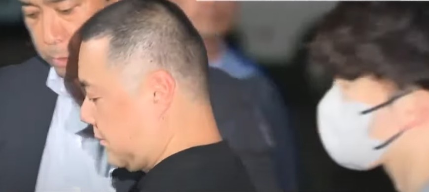 A suspect accused of using casino crime funds to buy a Tokyo high-rise apartment (center left).