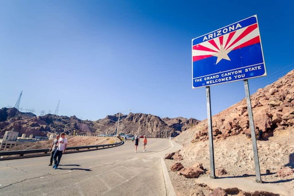 Arizona state welcome sign on a desert highway.
