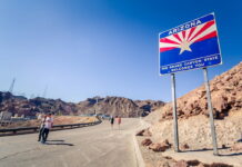 Arizona state welcome sign on a desert highway.