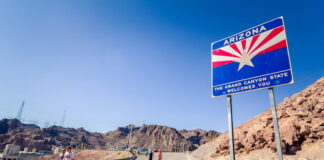 Arizona state welcome sign on a desert highway.