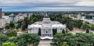 Aerial view of the California State Capitol building in Sacramento surrounded by trees