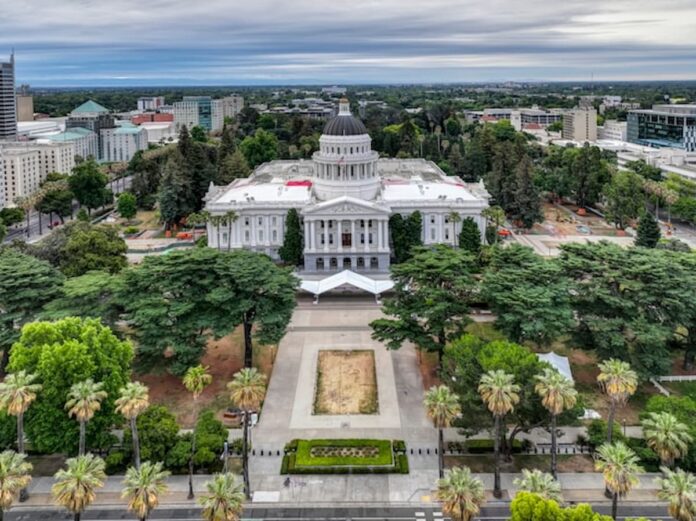 Aerial view of the California State Capitol building in Sacramento surrounded by trees