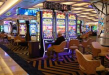 Gaming Arts Reportedly Bringing Evolution Slots to Land-Based Casinos Row of slot machines glowing with bright lights on a casino floor
